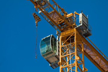 Cab modern construction crane on a background of blue sky