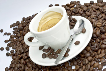 Cup of coffee sitting in a bed of coffee beans