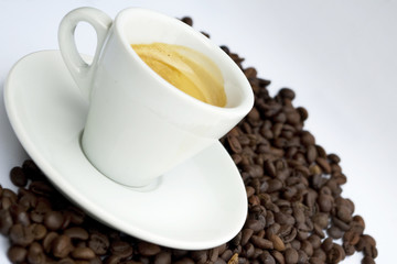 Cup of coffee sitting in a bed of coffee beans