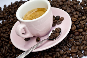 Cup of coffee sitting in a bed of coffee beans
