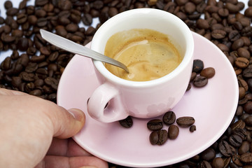 Cup of coffee sitting in a bed of coffee beans