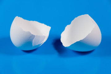 Two halves of broken eggshell (on a blue background)