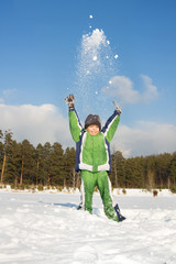 Happy child throwing up snow