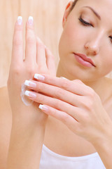 Obraz na płótnie Canvas Woman applying cosmetic cream on hands