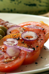 some organic tomatoes and red onion on a plate