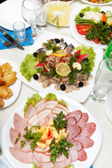 Table served with lots of appetizers and pork and fish plates