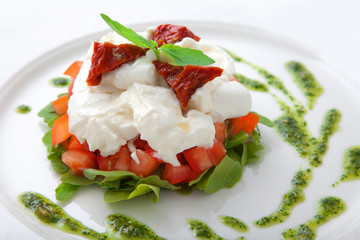 Dish with tomatoes, salad ruccola and cheese a mozzarella