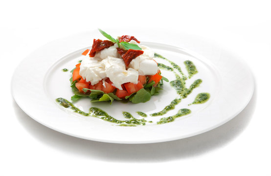Dish with tomatoes, salad ruccola and cheese a mozzarella