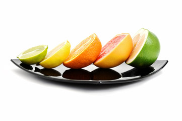 Naklejka na ściany i meble Halved citrus fruits on the plate (side)