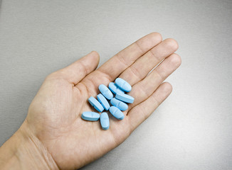 Blue pills in a hand