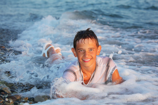 teenager boy swim in clothes in sea