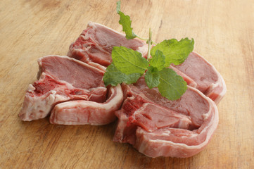 organic raw lamb chops on a timber board