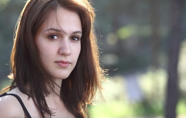 Close-up portrait of a very pretty young brunette woman outdoors