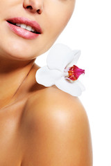 Flower on the shoulder of woman with healthy clear skin