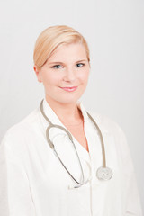 Young optimistic female doctor in uniform with stethoscope