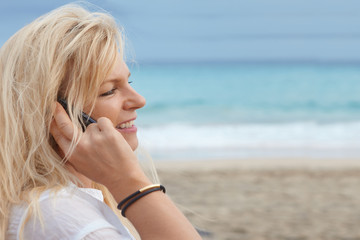 beautiful woman has a good call at the beach