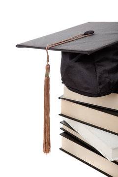 Graduation Cap On Top Of A Stack Of Books On White