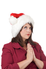 Young woman in Santa hat prays; isolated on white