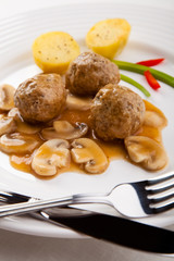 Roasted meatballs with mushrooms and boiled potatoes