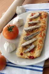 stone oven baked pizza with anchovy and tomato