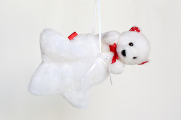 Hanging white teddy bears inside a peluche star-shaped sachet