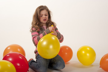 Fototapeta na wymiar little girl struggling to tie balloon