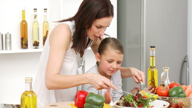 Mother and daughter preparing a salad