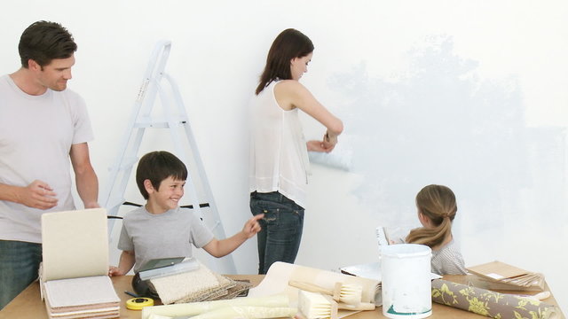 Family painting together a room at home