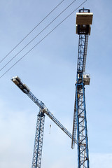Two cranes on the sky background