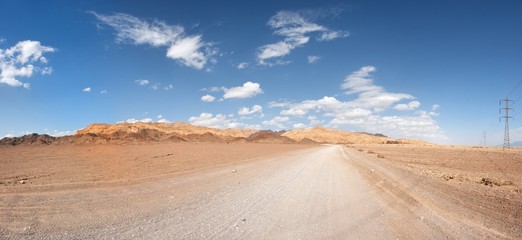 Road in the desert towards the distant rocks