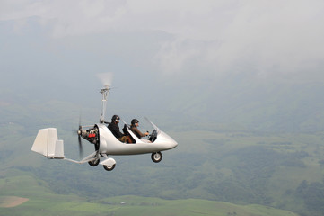 Autogyro flying over the tropical landscape