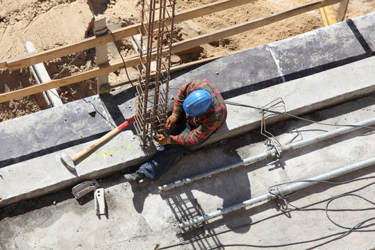 Worker working on a construction site column.