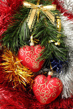 christmas hearts hanging on fir branch on tinsel background