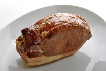 cooked organic back bacon joint on a plate