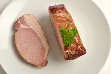 cooked organic back bacon joint on a plate