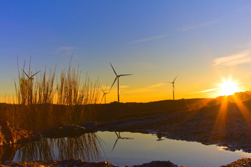 windmills at sunset in the top of a montain, alternative energy