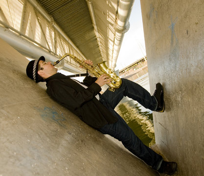 A Young Man With A Saxaphone Outdoors