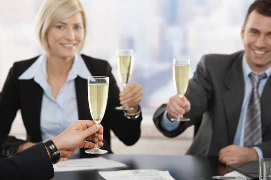 Business executives raising toast with champagne