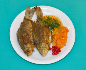 Fried fish in plate on a green background