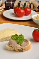 half bread roll with liver sausage on a plate