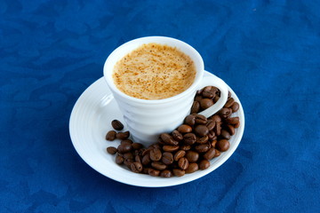 cup with coffee and grain expressed on blue background