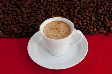 cup with coffee and grain expressed on red background