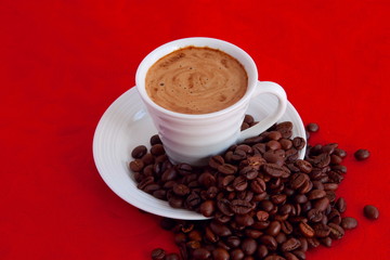 cup with coffee and grain expressed on red background