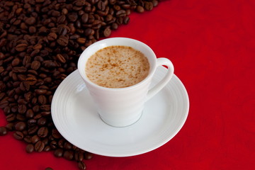 cup with coffee and grain expressed on red background