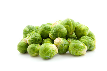 Stacked fresh Brussels sprouts over white background