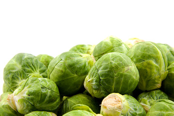 Fototapeta premium Stacked fresh Brussels sprouts over white background