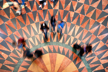 overhead shot of commuters walking on geometrical tile pattern at union station in los angeles...