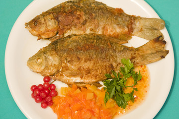 Fried fish in plate on a green background