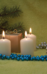 Obraz na płótnie Canvas Christmas candles and gift on green background