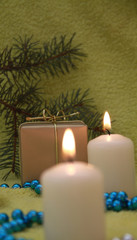 Christmas candles and gift on green background
